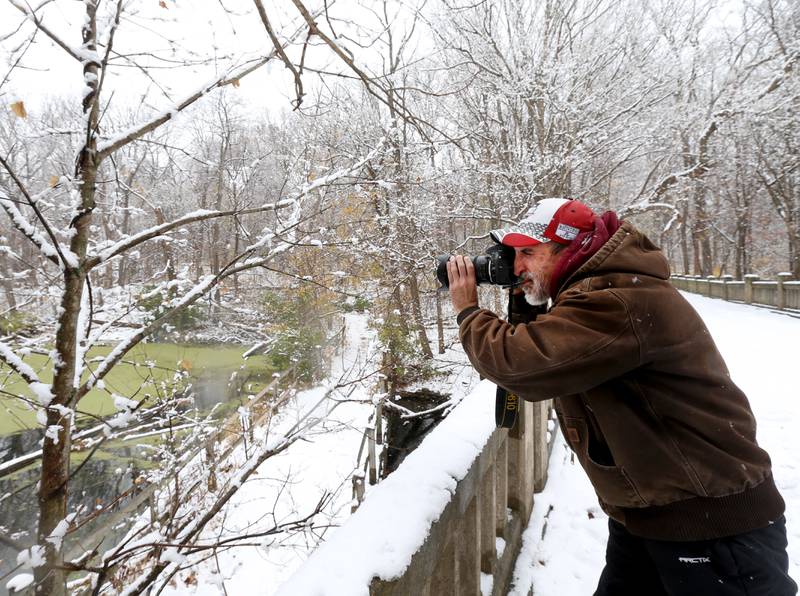 Local photographer Eddie Rodriquez of La Salle, takes photos of the freshly fallen snow over the bridge at Matthiessen State Park on Tuesday, Nov. 15, 2022 in Oglesby.