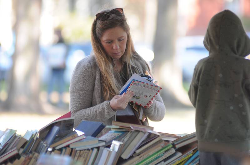 April Dzubic, of St. Louis, Mo., and nephew Noah Salz, of Ottawa, look at used books Saturday, Oct. 16, 2021, at the American Association of University Women annual book sale during Lit Fest at Washington Square in Ottawa.
