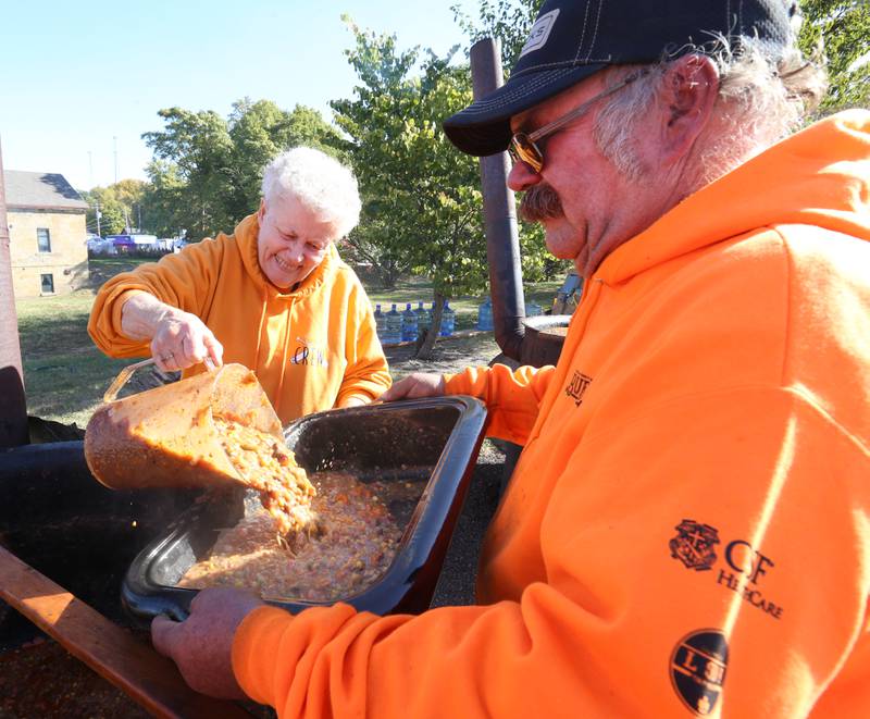Volunteers Ruth Herbst pours a batch of Burgoo for Nathan Miller during the 52nd annual Burgoo on Sunday, Oct. 9, 2022.