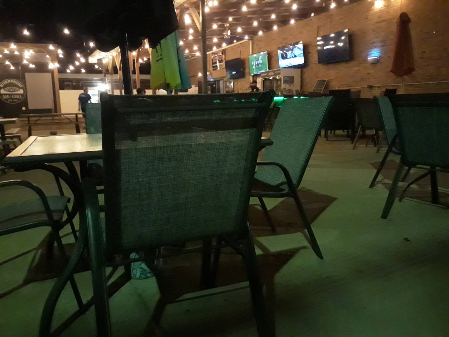 The outdoor patio with a bar at Riverfront Bar and Grill in Peru provides views of the river and a place to relax outdoors for a meal or drinks.