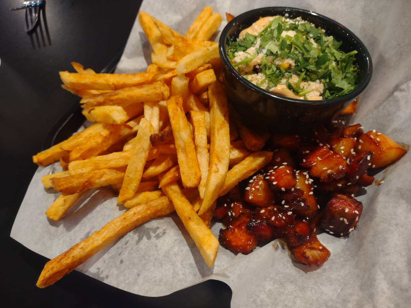 The sticky pork belly tossed with a side of sweet chili at Brennan's Bar and Grill in Oglesby is served with two sides. In this case, hand cut fries and a dish of street corn.