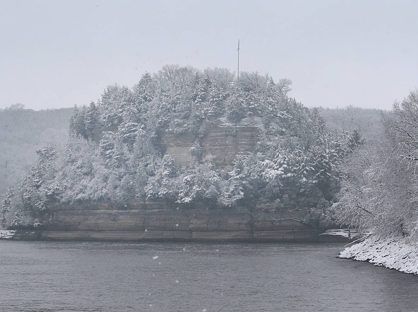 The famous Starved Rock landmark blanketed in snow cover rises magnificently over the Illinois River on Wednesday, Jan. 25, 2023 near Utica.