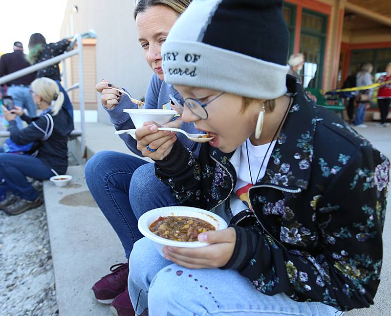 Annabelle Jachna and her mother Beth Borgo eat Burgoo on the steps of the La Salle County Historical Society Museum during the 52nd annual Burgoo on Sunday, Oct. 9, 2022.