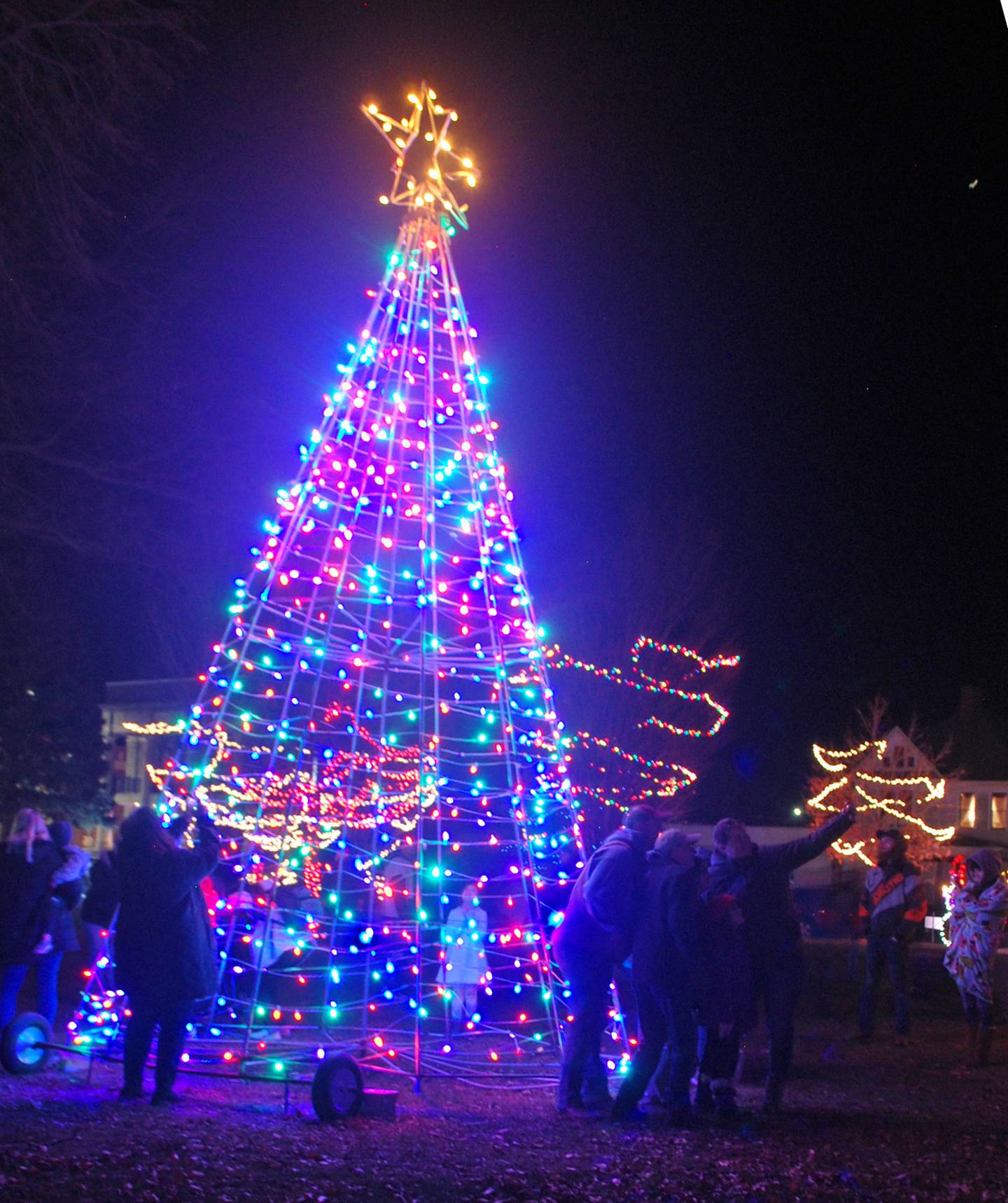 Families take photos and selfies near the tall LED-lit tree in Streator City Park after the Light Up Streator Committee illuminated its display for the holiday season Saturday, Nov. 26, 2022.