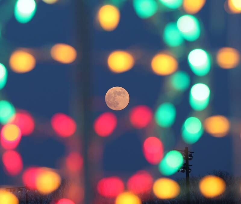 A full moon illuminates through Christmas decorations at the Celebration of Lights on Thursday, Dec. 8, 2022 at Rotary Park in La Salle.