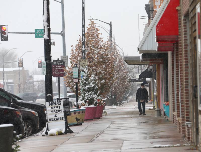 A pedestrian walks along the sidewalk as the snow falls near First and Joliet Streets on Tuesday, Nov. 15, 2022 downtown La Salle.